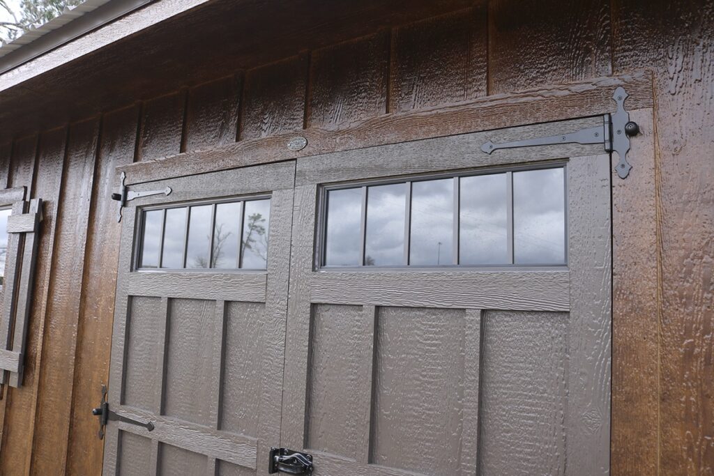 Carriage house doors with transom windows and black strap hinges