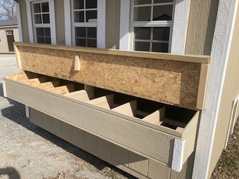 Exterior egg box open on the side of a chicken coop