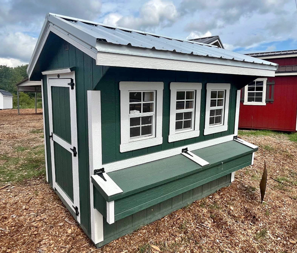 Green chicken coop with three windows and an egg box